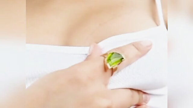Asian woman flashing tits in white bra, green ring closeup