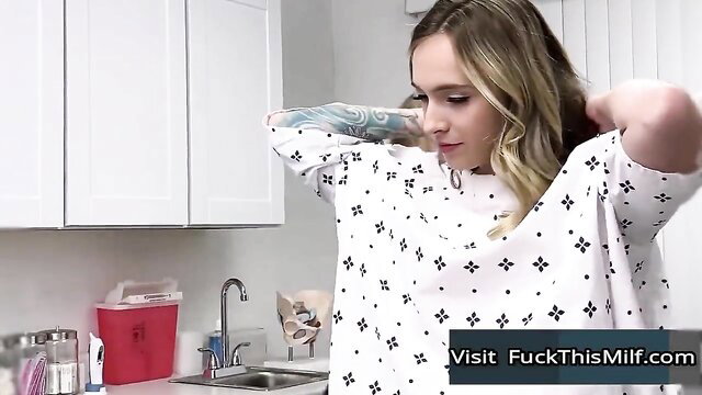 Busty tattooed patient in open gown for fertility exam