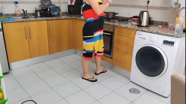 Horny stepmom in colorful shorts stands in kitchen, flashing pussy to son's friend