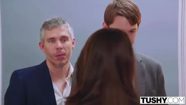 Brunette with long hair between two suited men in Tushy threesome tease