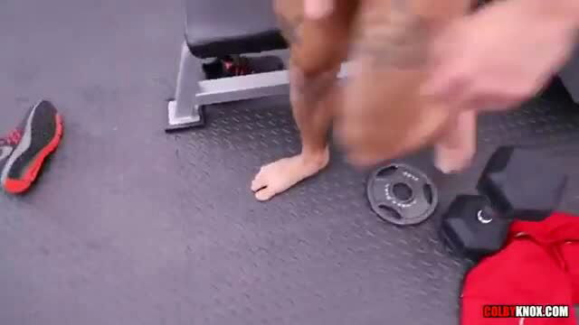 Tattooed muscular man nude footjob in gym with weights