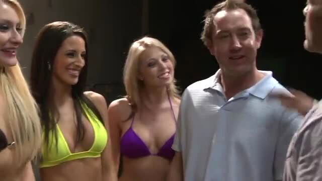 Blonde in yellow bikini surrounded by sexy brunettes and men at auto service