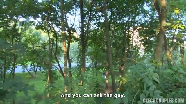 Amateur swinger couple in lush green forest by river, outdoor action