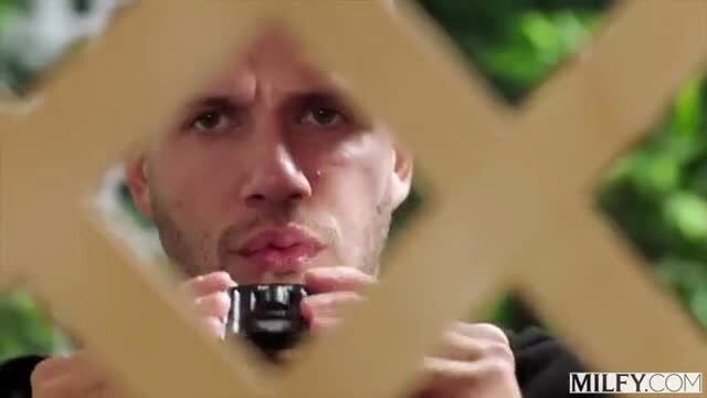 Dan Damage peeks through fence holding camera in MILF next-door scene