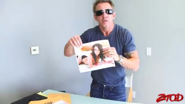 Tanned guy holding explicit photo of busty brunette babe in Zero Tolerance vid