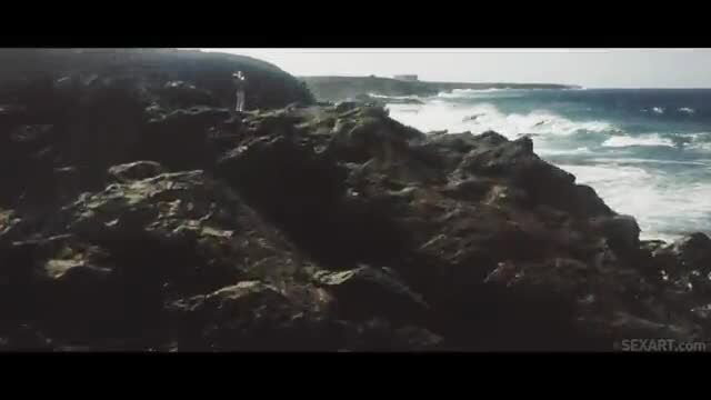 Woman stands nude on rocky ocean cliff in Espuma De Mar by SexArt