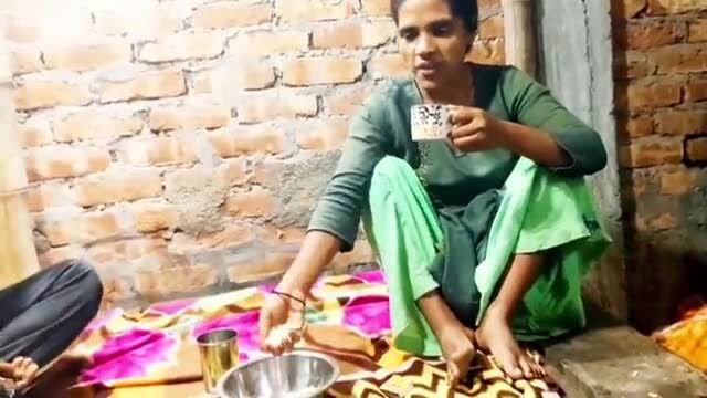 Desi Indian Bhabhi sipping chai in green salwar kameez, bare feet