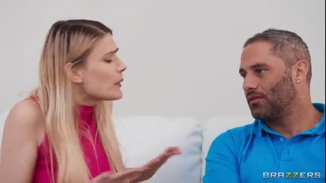 Blonde bombshell in pink top argues passionately with handsome bearded man on couch