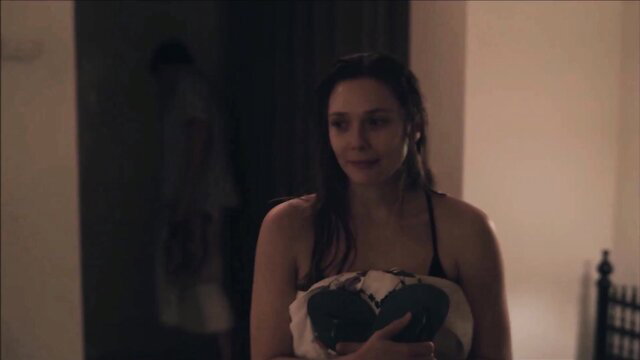 Wet brunette celeb holding towel over tits in nude scene