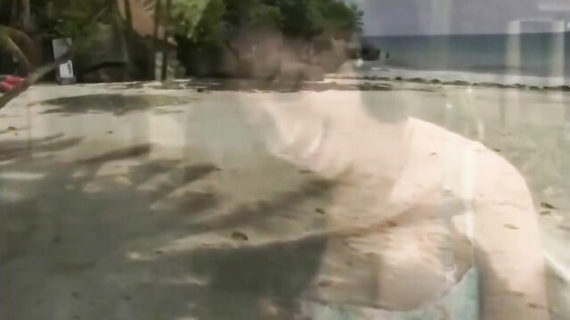 Blurred Filipino ladyboy beauty on beach in white swimsuit