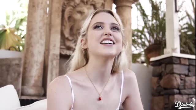 Blonde babe with natural big tits smiling in white tank top, sunny outdoor tease