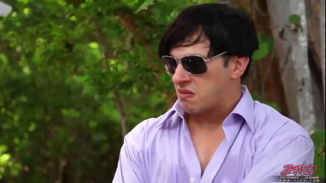 Man in purple shirt and shades smirks in lush jungle, Zero Tolerance heat