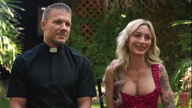 Priest and busty blonde Kathryn Mae in revealing red dress outdoors