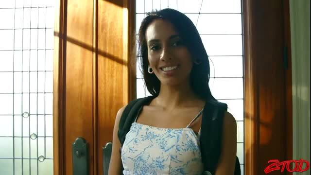 Smiling brunette Latina in floral sundress and backpack smirks seductively