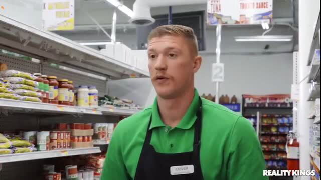 Hot store clerk in green uniform at grocery aisle
