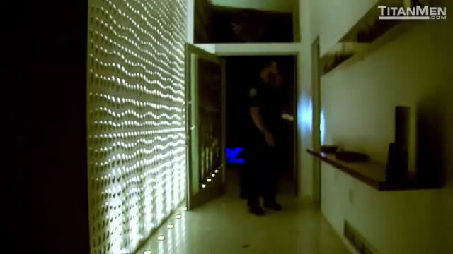 Cop in tight uniform enters dimly lit hall in Police Boink gay porn scene