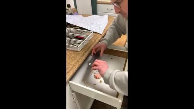 Man in glasses rummages kitchen drawer with utensils in amateur clip