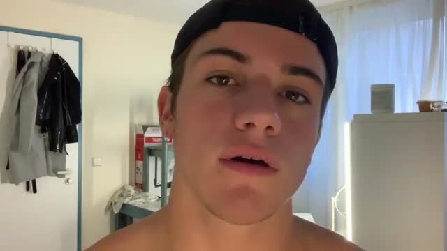 Hot shirtless twink in black cap taunts with open mouth closeup