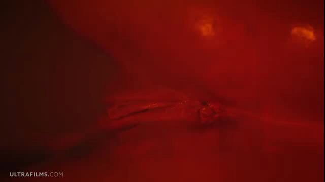 Gorgeous oiled girl teases naked body closeup in red glow