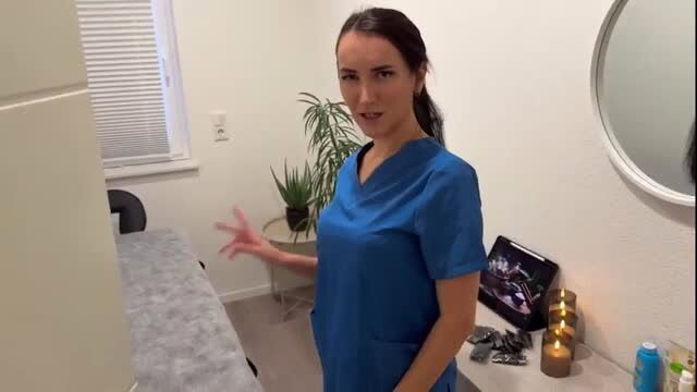 Hot brunette nurse in tight scrubs gesturing in massage room