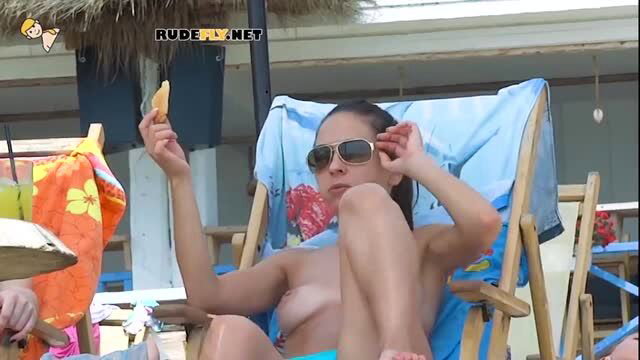 Nudist girl sunbathing in a beach chair