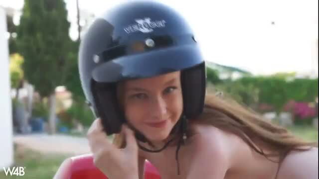 Busty brunette naked with helmet on red motorcycle outdoors