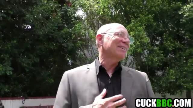 Bald old rich cuck in suit smiles outdoors in cuckold scene