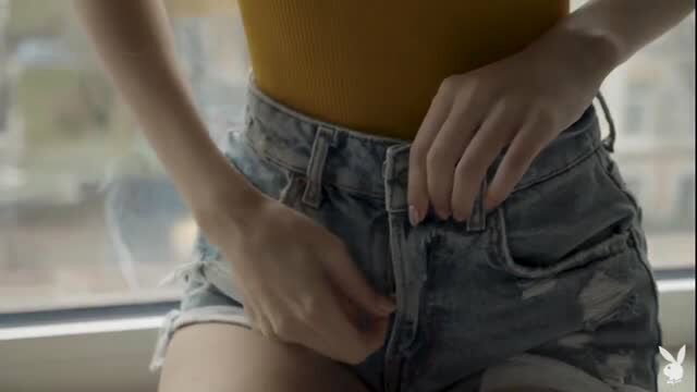Charming Brunette unbuttons ripped denim shorts, teasing striptease