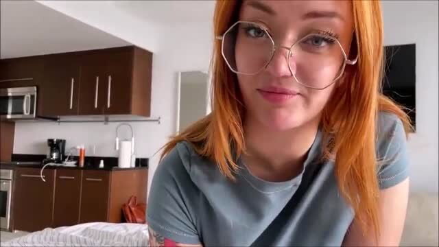 Emma Magnolia redhead in glasses smiles teasingly in kitchen