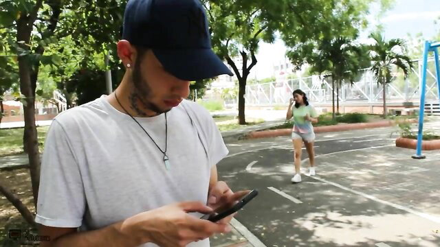 Latina guy checks phone as hot girl in shorts walks by on blind date tease