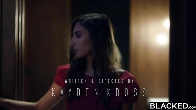 Gianna Dior in red dress, seductive gaze in Blacked scene