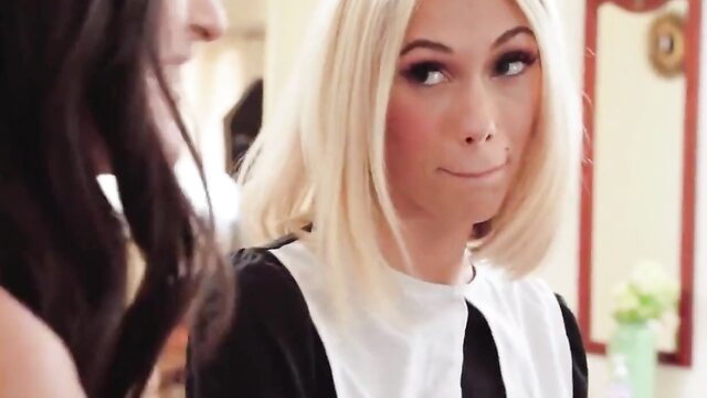 Blonde in schoolgirl outfit with brunette, smirking closeup tease