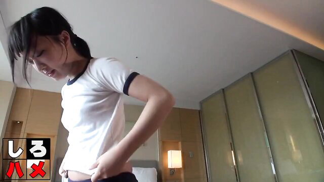 Japanese schoolgirl in tight white shirt and skirt, teasing pose in hotel room