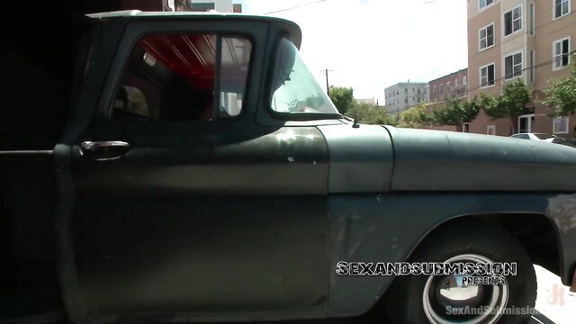 Britney Amber leaning on vintage green truck in sexy dress, Kink studio