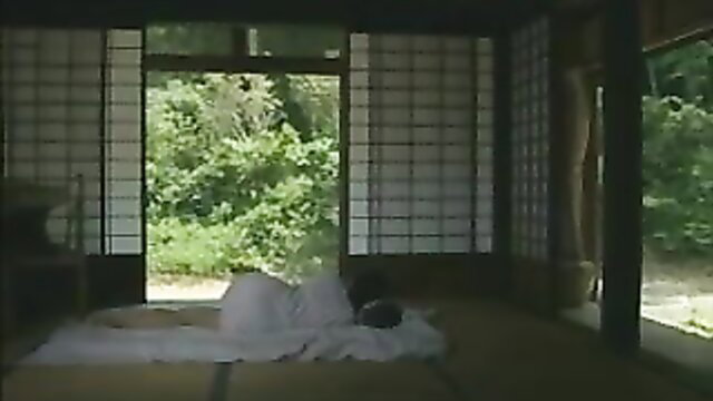 Nude Japanese woman lying on futon in traditional room, softcore tease