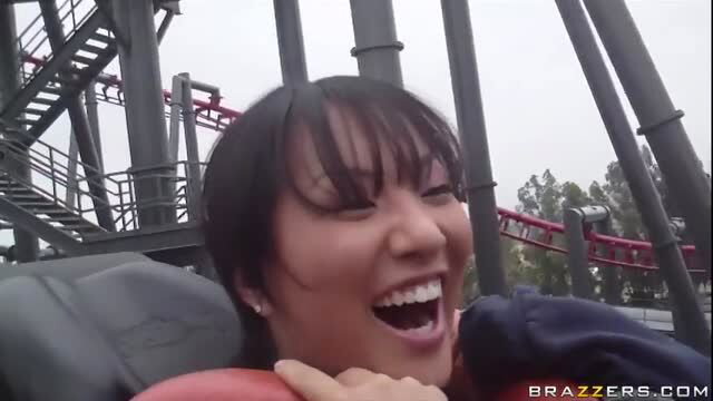 Asa Akira screaming with thrill on rollercoaster at theme park