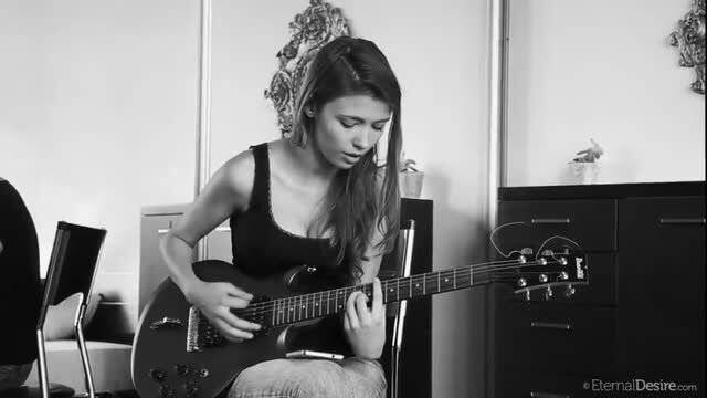 Babe with nice round breasts playing guitar topless