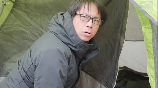 Japanese man in winter jacket inside a tent, shocked expression