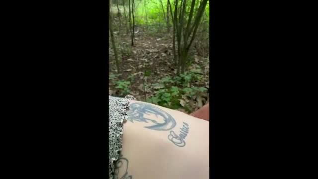 Amateur tattooed hand in forest woods, cursive name tattoo visible