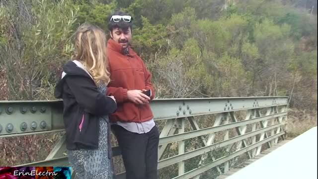 Couple embracing on bridge in outdoor setting