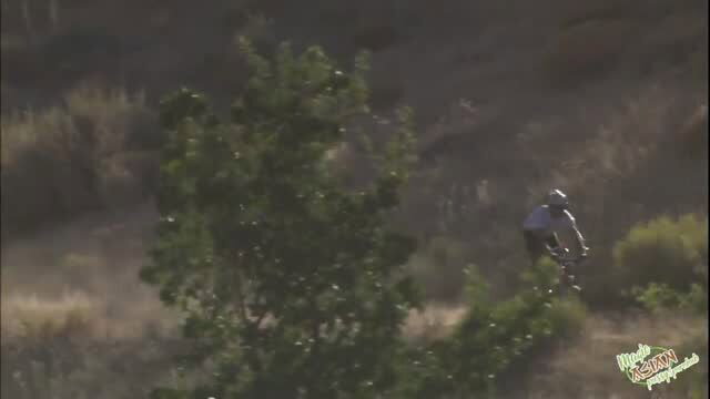Asian cyclist in helmet riding on dirt trail outdoors