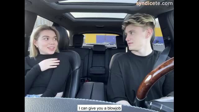 Blonde woman offering blowjob to driver in car interior