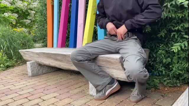 Mature man adjusting pants on bench outdoors