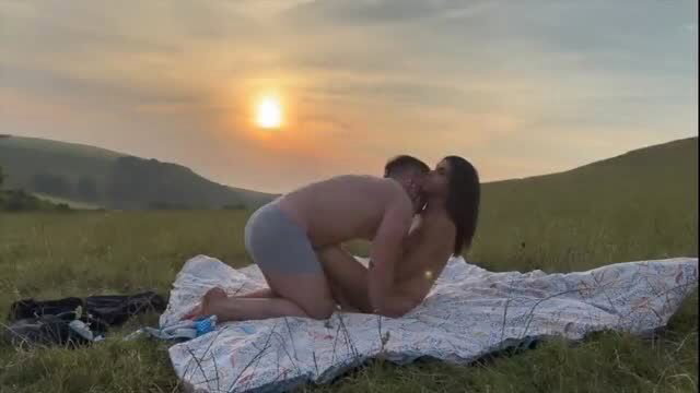 Couple having outdoor sex in a field at sunset with creampie