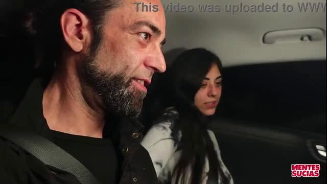 Man with beard driving with dark-haired woman in car