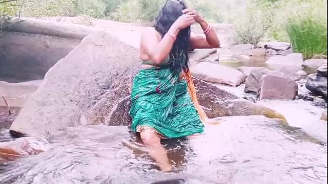 Telugu aunty in wet green saree bathing at outdoor waterfall