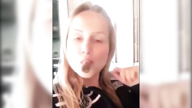 Blonde woman with sultry eyes smoking cigar closeup