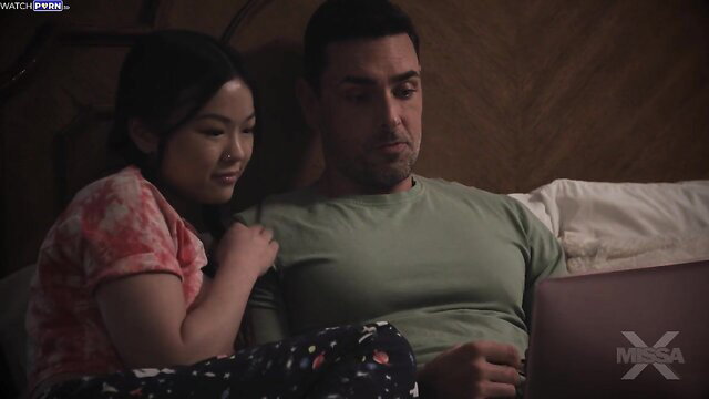 Lulu Chu cuddles with daddy on bed in cozy pajamas