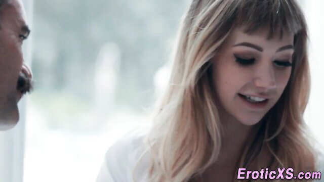 Pretty blonde with bangs smiles at man in erotic closeup