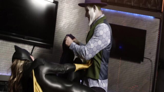 Batgirl in shiny latex catsuit pinned by Joker in cosplay domination scene
